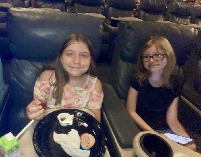 angel and her friend in the theater watching despicable me 4
